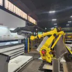 automated press brake with robotic arm working on structural frame